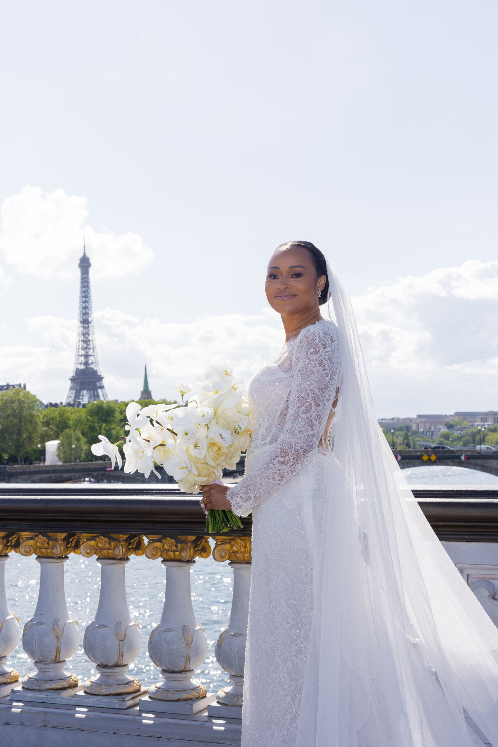 Mariée tenant un bouquet blanc devant la Tour Eiffel illustrant ce qui rend cette formation Sweet Heart Table UNIQUE - Hibiscus Blooms
