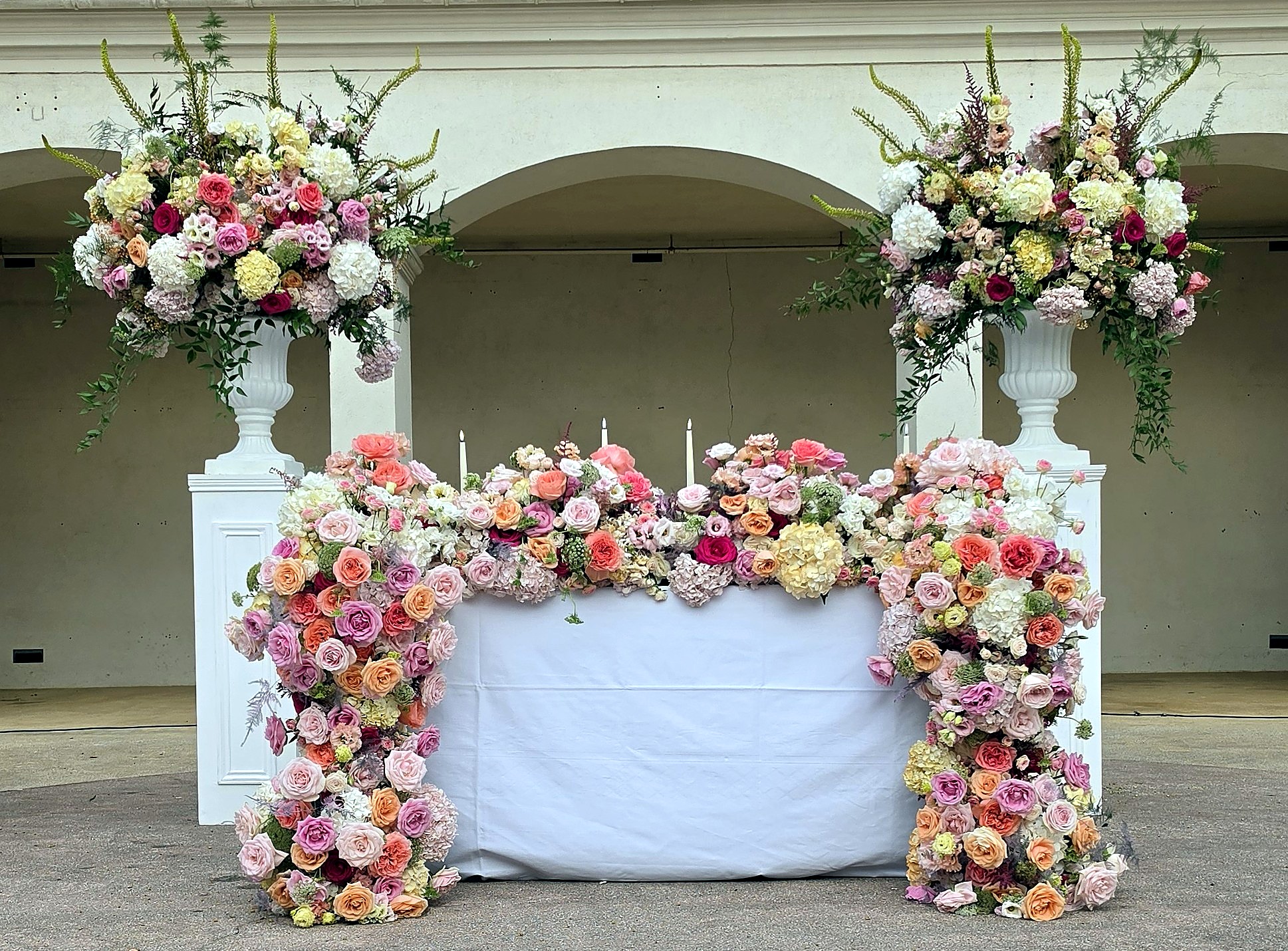 Buffet floral sweet heart table sous arcades, tons rose, pêche et blanc